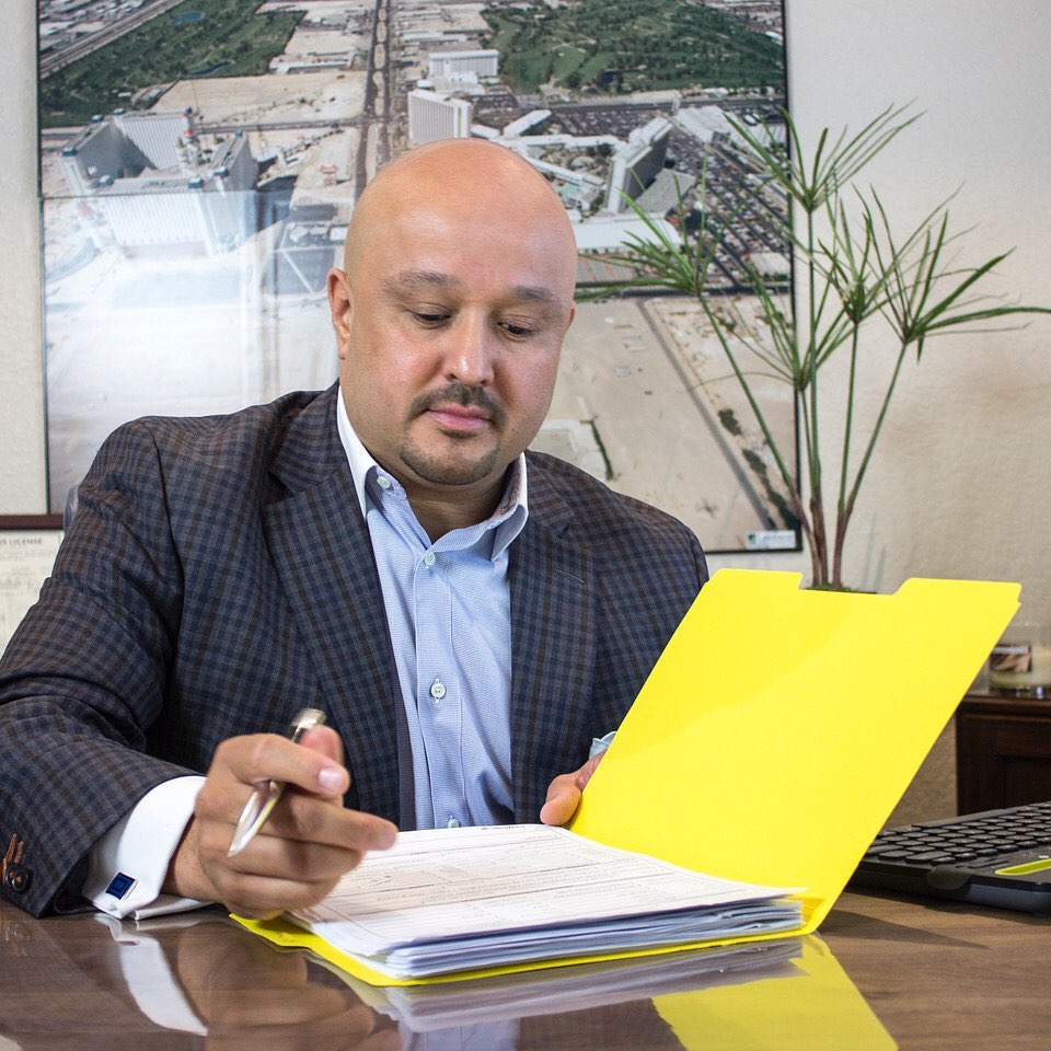 Jesse Fonseca reviewing documents at his Las Vegas office desk